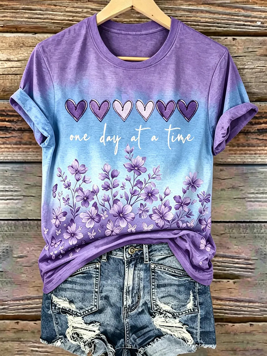 Damen-T-Shirt mit lila Blumenmuster und Aufdruck zur Sensibilisierung für die Alzheimer-Krankheit